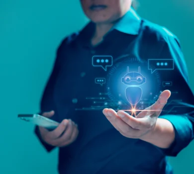 Osoba držiaca holografickú vizualizáciu AI nástrojov, vrátane ikony chatbota, znázorňujúcu moderné technológie a umelú inteligenciu.