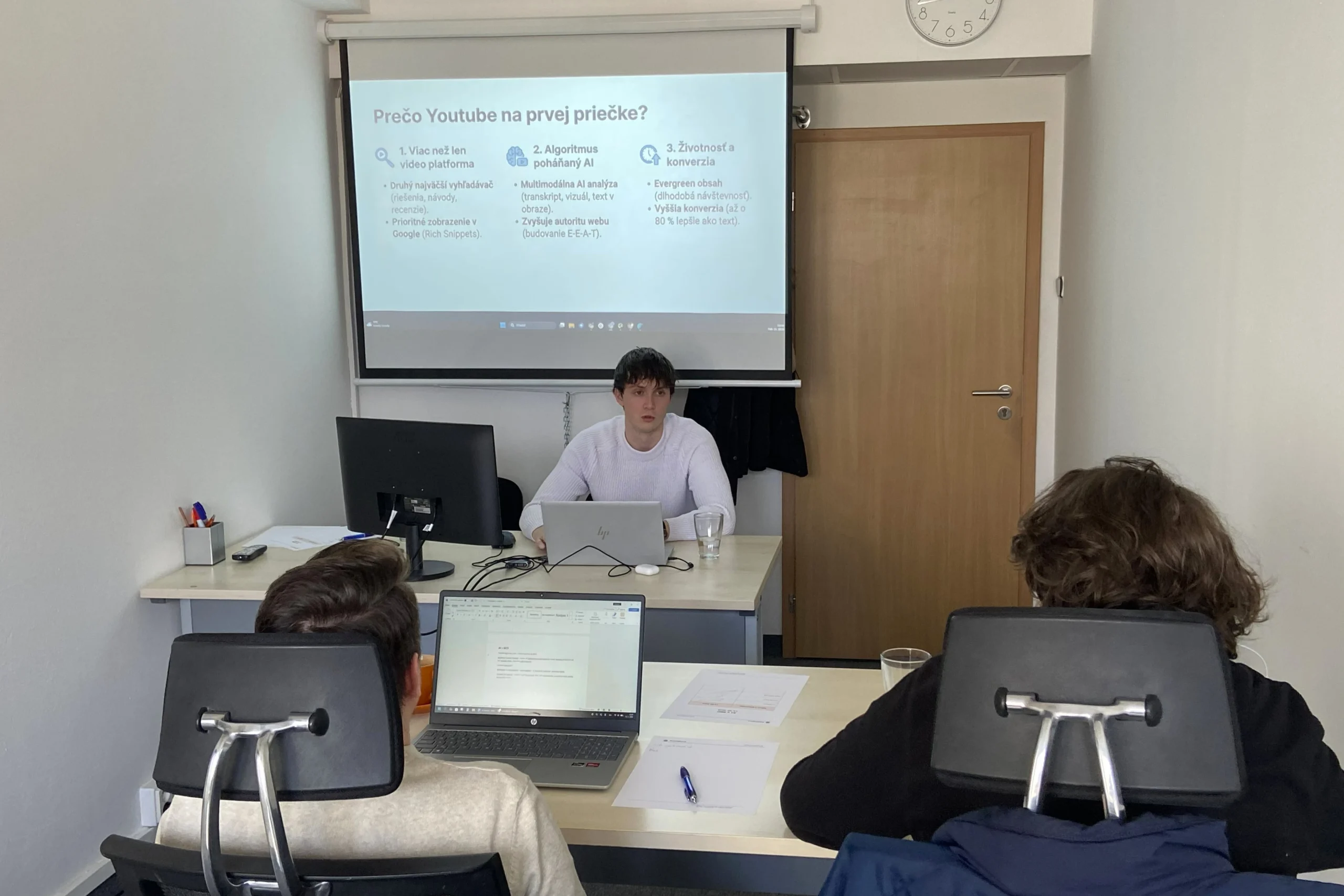 Lektor na prezenčnom kurze AI v SEO vysvetľuje na projektore, ako používať AI nástroje v praxi